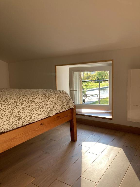 a bedroom with a bed and a window at Le Clos des Grands Frênes in Pons