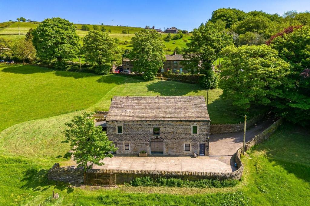 an aerial view of an old stone house in a field at Meadow Barn in Rishworth