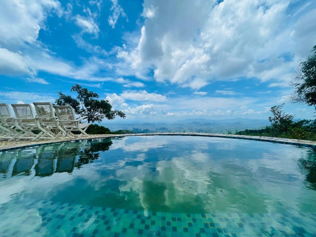 una piscina con sillas y un cielo azul en Xuân Phong Ecolodge en Hòa Bình