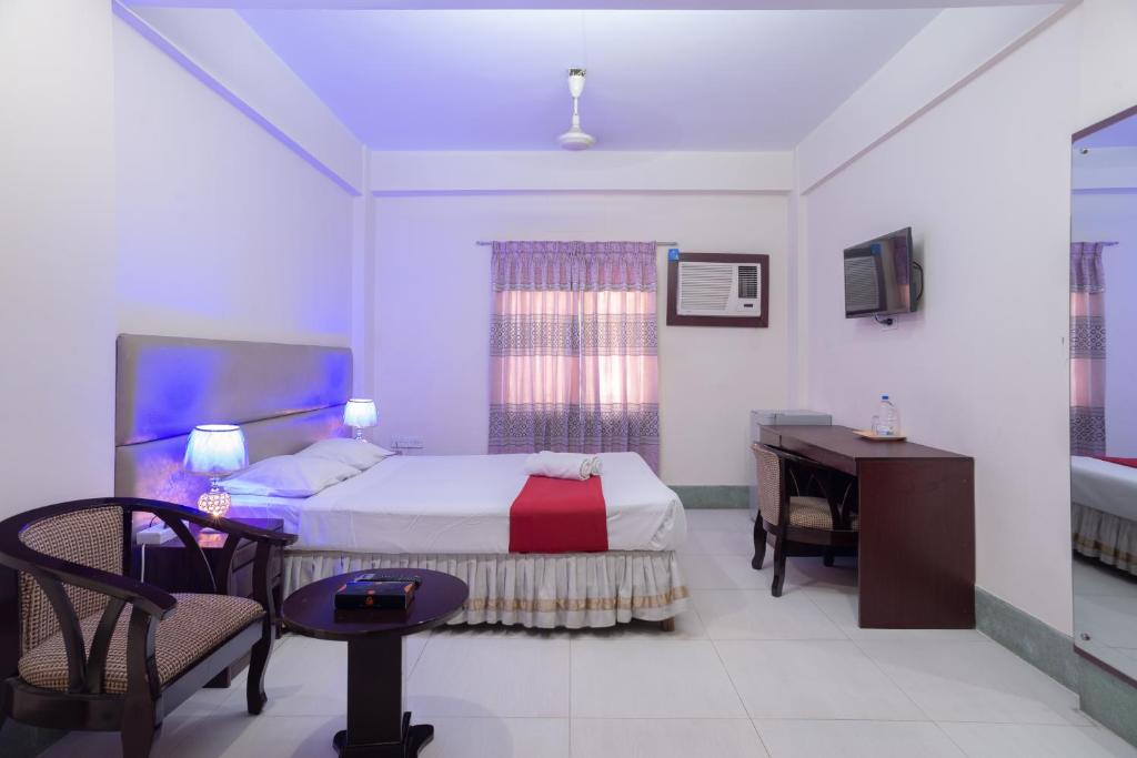 a bedroom with a bed and a desk and a desk at Hotel Golden Inn Chattagram Ltd in Chittagong