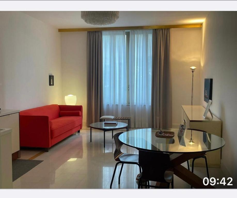 salon z czerwoną kanapą i stołem w obiekcie Corso Novara 5 Design Apartments w mieście Neapol