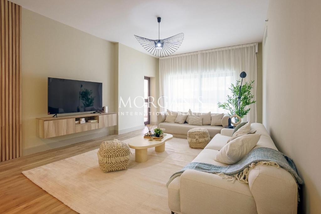 a living room with a couch and a tv at Luxury 2 bedrooms apartment in fairmont residences in Dubai