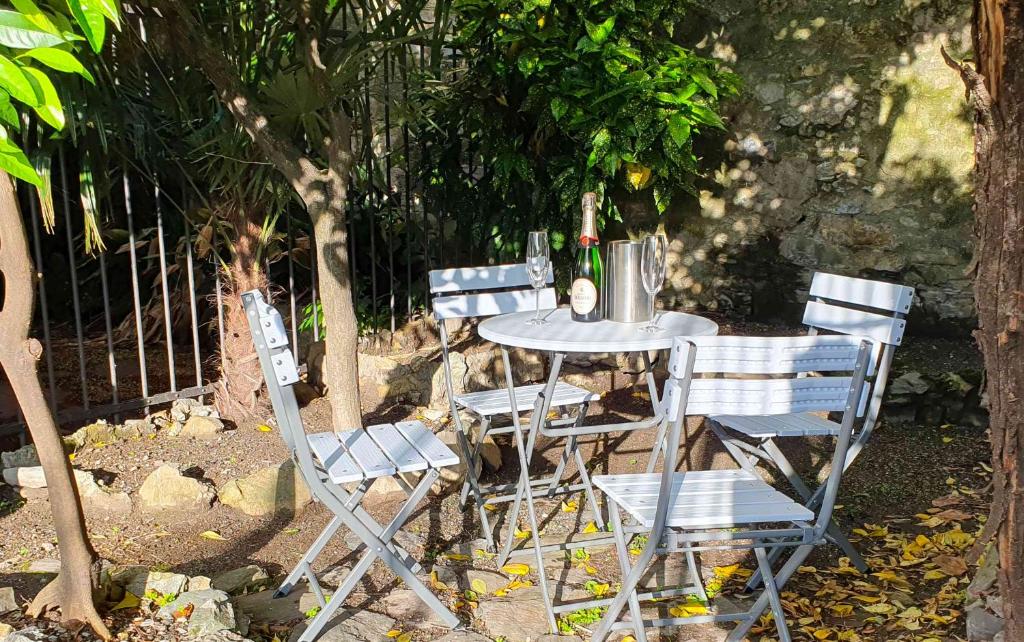einen Tisch mit vier Stühlen und einen Tisch mit einem Baum in der Unterkunft [La casa dell'Arte] con parcheggio gratuito in Genua