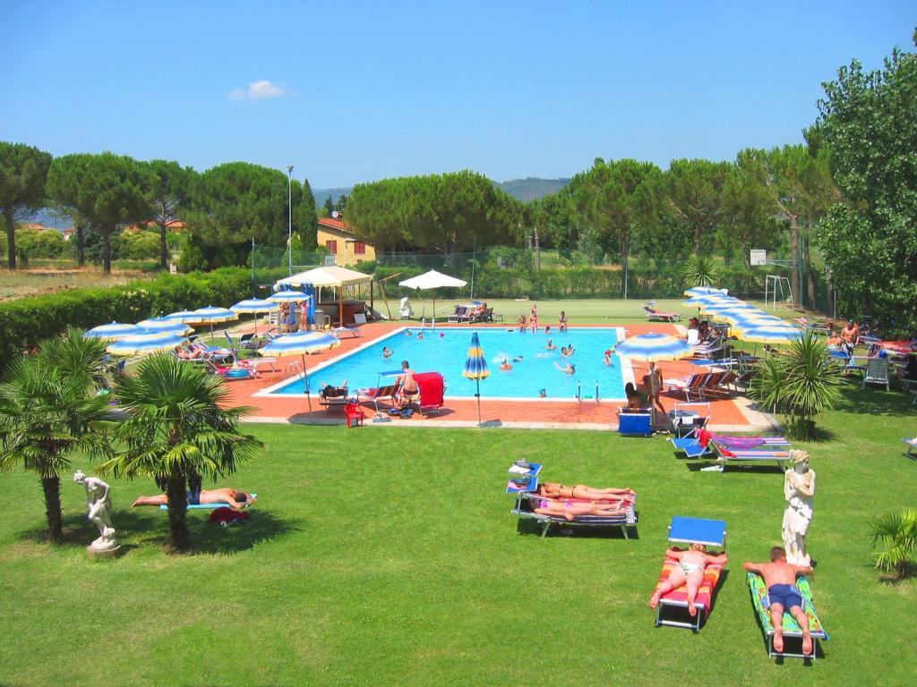 a large swimming pool with people in a park at Badiaccia Village Camping in Castiglione del Lago