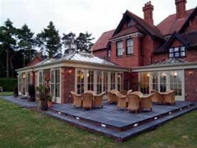 a large house with a patio with tables and chairs at The Old Vicarage in Bridgnorth