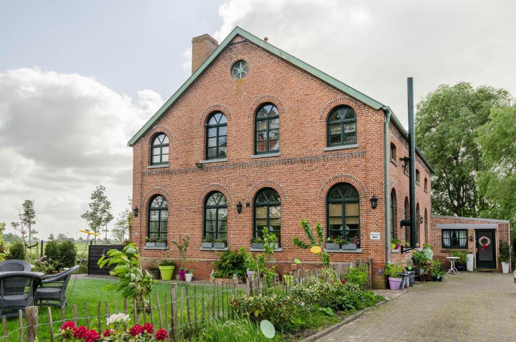 a red brick building with a garden in front of it at Haus Soltborg in Jemgum
