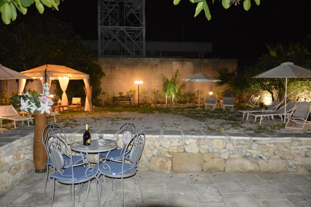 een tafel en stoelen met een fles wijn erop bij Corte Soleto 22 in Martano