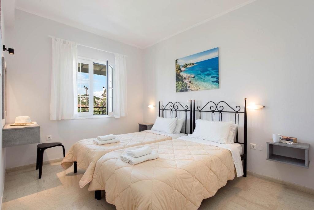 a bedroom with a large bed and two windows at Balaris Apartments in Kassiopi