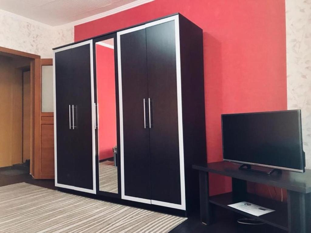 um grande armário preto e branco com uma televisão em ЛЮКС на Юго-востоке,Степной1 em Karaganda