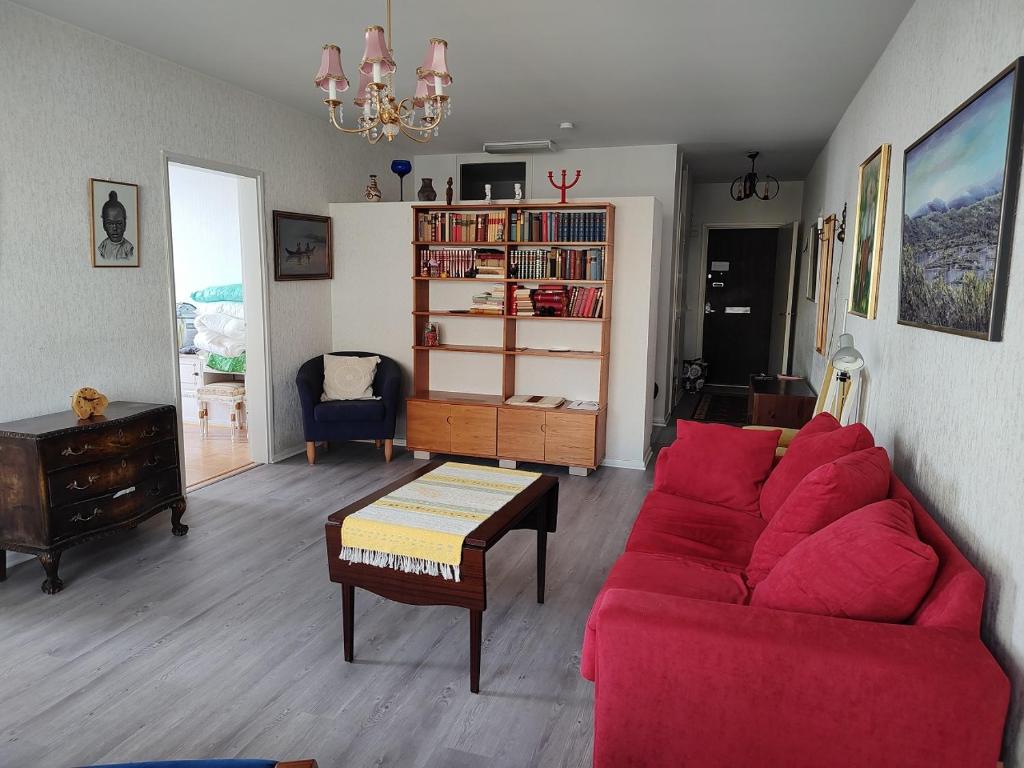 ein Wohnzimmer mit einem roten Sofa und einem Tisch in der Unterkunft Cozy Nest, apartement in the center of Rovaniemi in Rovaniemi