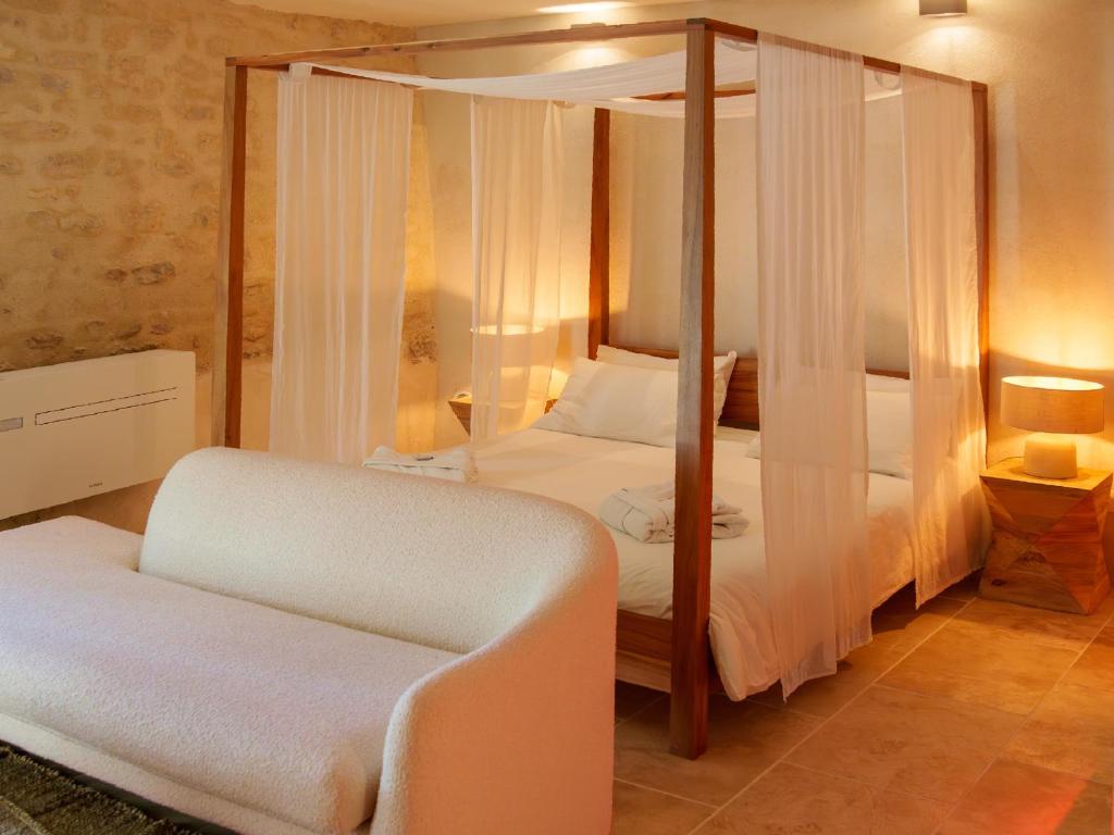 une chambre avec un lit à baldaquin et une chaise dans l'établissement Love in Taulignan, à Taulignan