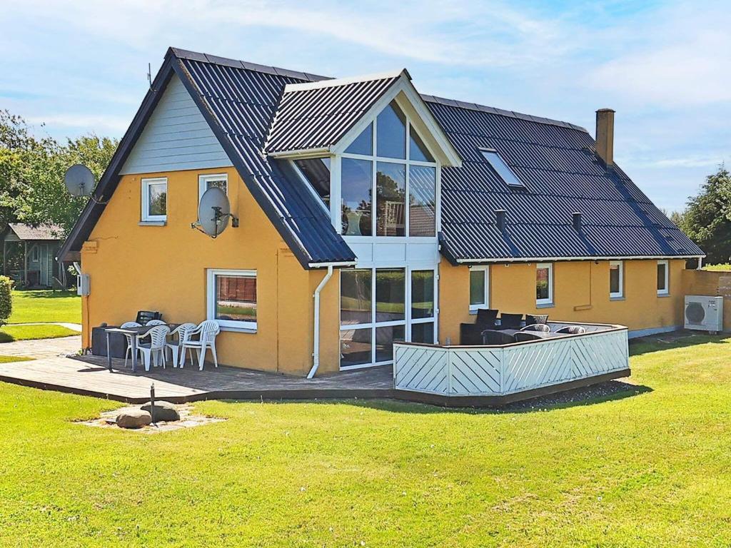 a large yellow house with a table and chairs at 10 person holiday home in Vinderup in Vinderup