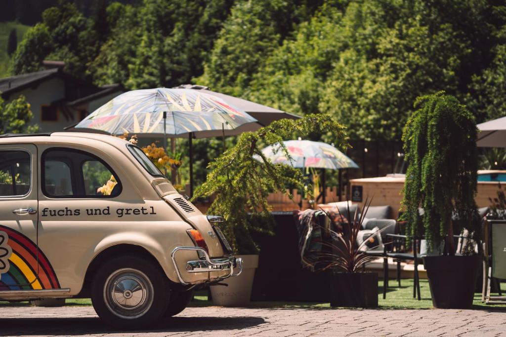 un camión estacionado junto a una mesa con sombrillas en Fuchs und Gretl en Saalbach Hinterglemm