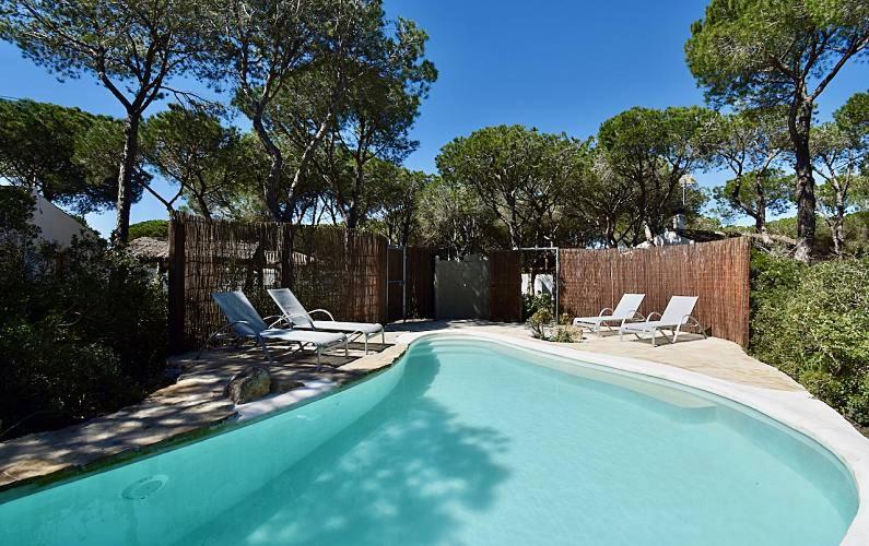 a swimming pool with lounge chairs and a fence at Casa Palmito 2 in Chiclana de la Frontera