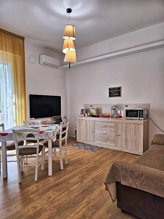a living room with a dining table and a tv at La Ca' Bianca Affittaly Rooms in Castenaso