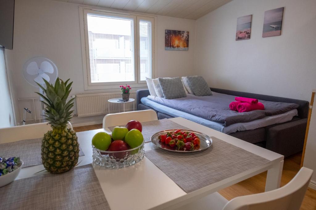 a living room with a table with a bowl of fruit at Araucarias apartment in Kotka