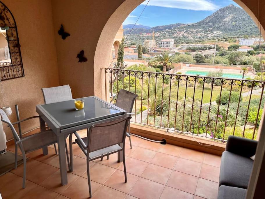 Cette chambre dispose d'un balcon avec une table et des chaises. dans l'établissement Joli studio tout confort proche toutes commodités dans residence calme, à LʼÎle-Rousse