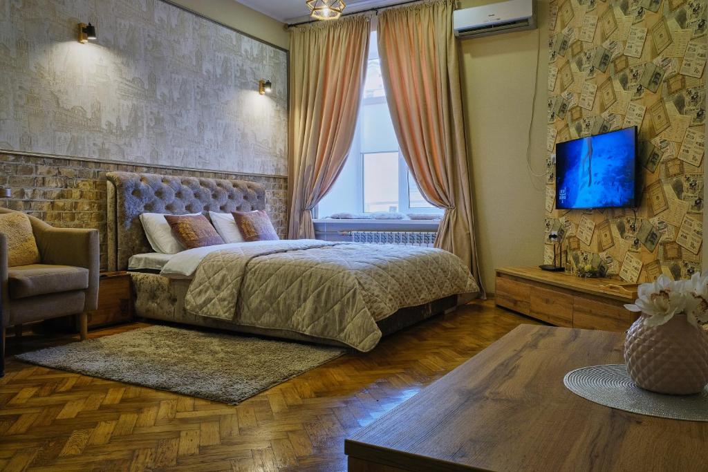 Central Apartments في أوديسا: غرفة نوم بسرير وتلفزيون على جدار