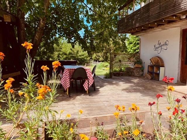 - une terrasse avec une table, des chaises et des fleurs dans l'établissement La Guinguette de Cormatin, à Cormatin