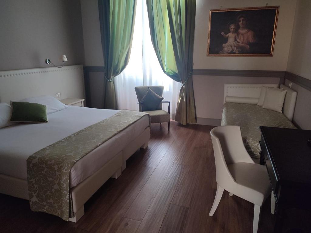 a bedroom with a bed and a chair and a window at Basilica Hotel in Rome