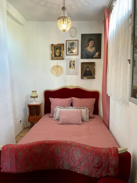 um quarto com uma cama vermelha e uma colcha rosa em Relax & Jacuzzi proche cité de Carcassonne em Pennautier