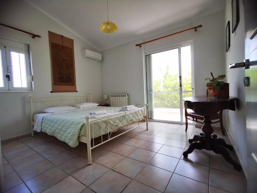 - une chambre avec un lit, une table et une fenêtre dans l'établissement Villa Irene, à Kos