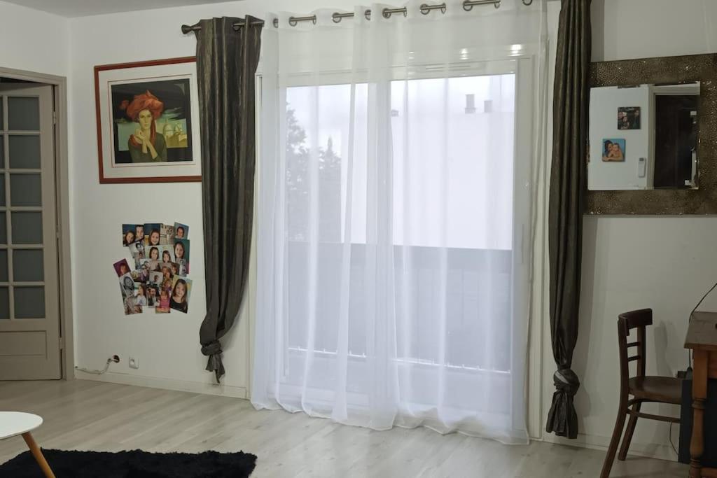 ein Fenster mit weißen Vorhängen im Wohnzimmer in der Unterkunft Appartement agréable pour 6 in Biguglia