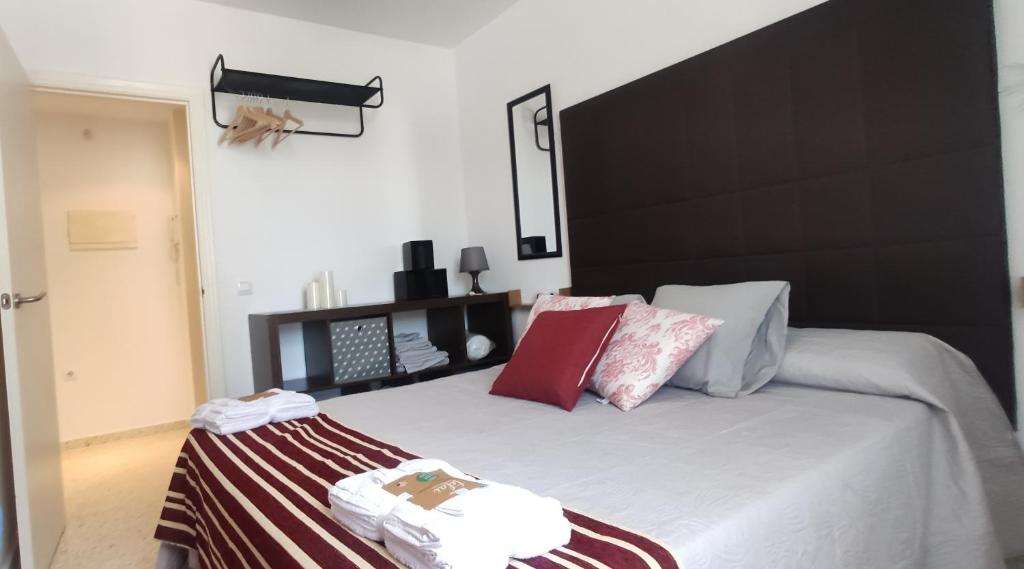 a bedroom with a large bed with a black headboard at JT CHICLANA, ,Parking, Aire, Wifi, TV, Terraza in Chiclana de la Frontera