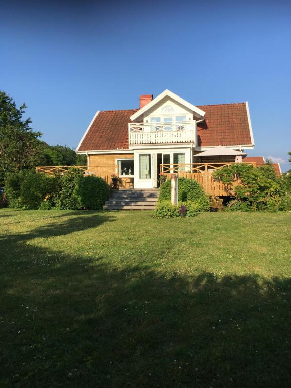 a house with a porch and a deck on a lawn at Bo nära strand och city. in Västra Frölunda