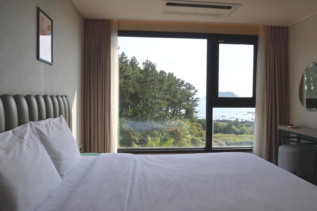 Postel nebo postele na pokoji v ubytování Hotel Seogwipean