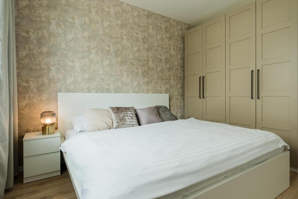 una camera da letto con un grande letto bianco e armadi di Urban & Green Apartments by Ambiente a Prievoz