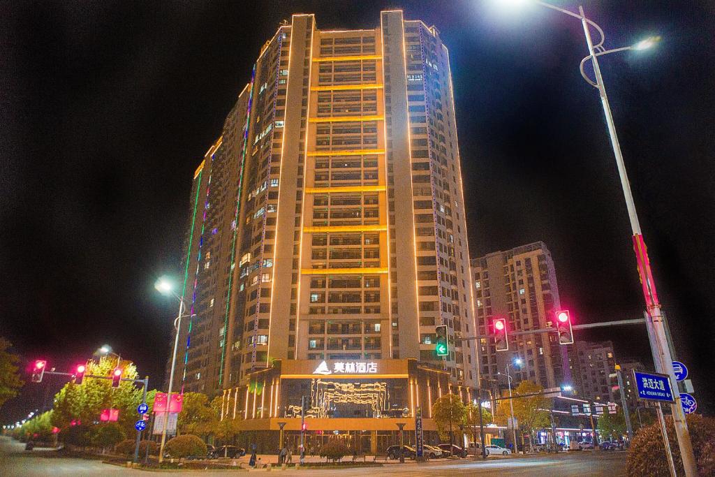 um edifício alto à noite numa cidade em Morning Hotel, Poyang Sports Center em Boyang