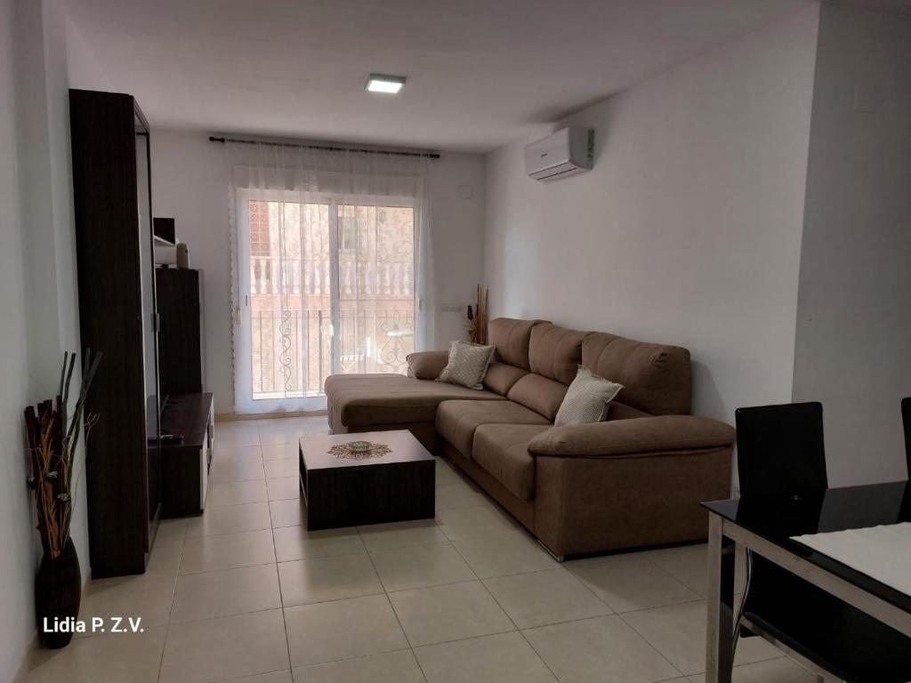 a living room with a brown couch and a window at Alojamiento turistico Ribagorza in El Lligallo del Gànguil