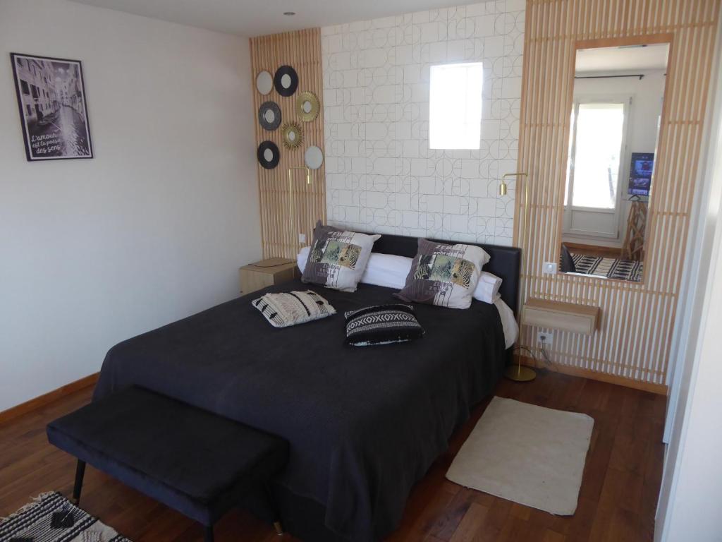 1 dormitorio con 1 cama negra y 1 silla en Les 2 dauphins, en Le Barcarès