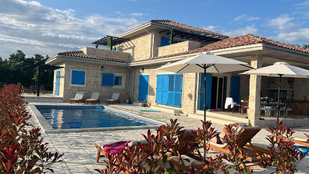 uma casa com uma piscina em frente em Villa Mare Blue em Žminj