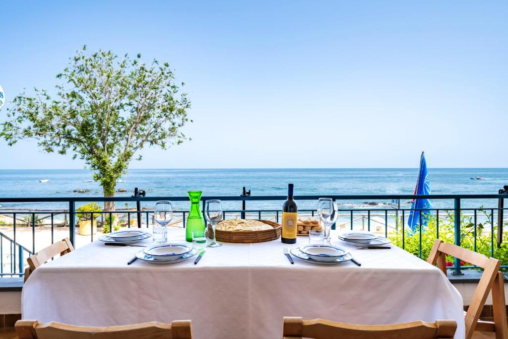 una mesa con copas de vino y vistas al océano en Casa sulla spiaggia en Cala Gonone