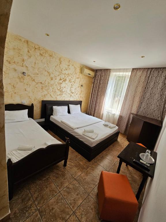 a hotel room with two beds and a table at Hotel Jiul in Eforie Sud