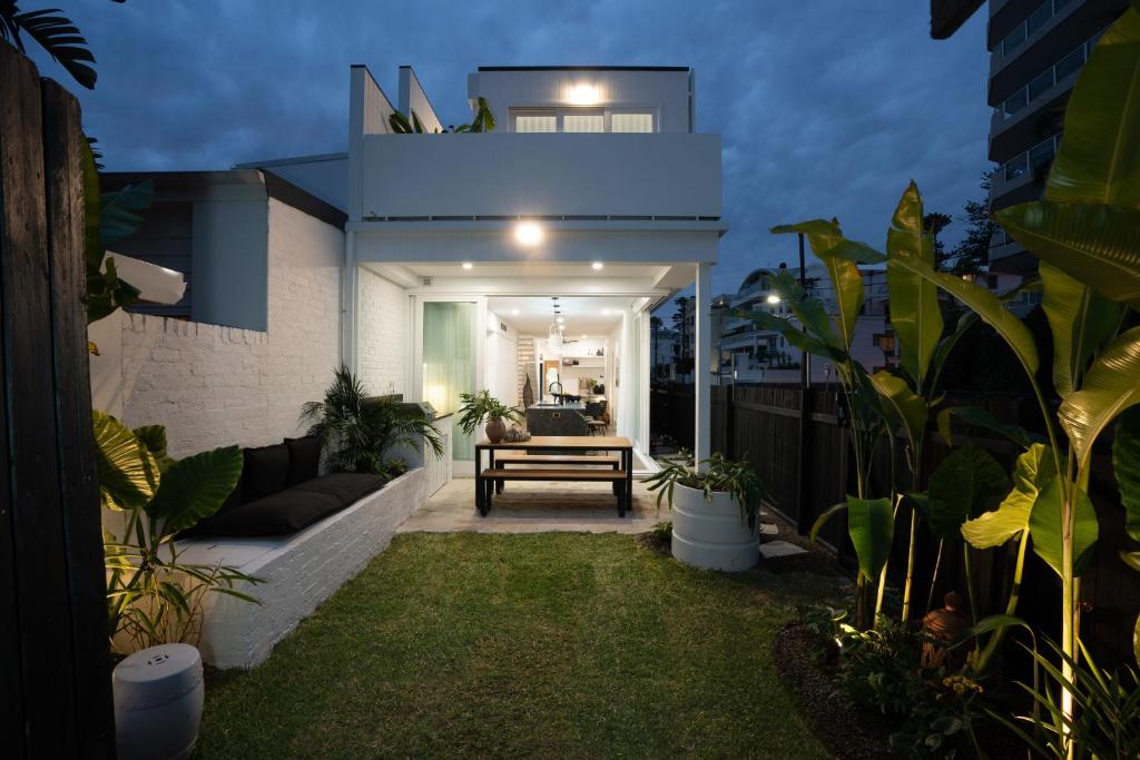 um quintal de uma casa à noite com plantas em The Manly House - 100 steps from Manly Beach em Sidney