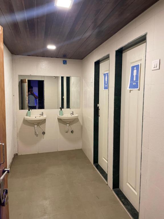 ein Badezimmer mit zwei Waschbecken und zwei Spiegeln in der Unterkunft Monalisa lawns in Thane