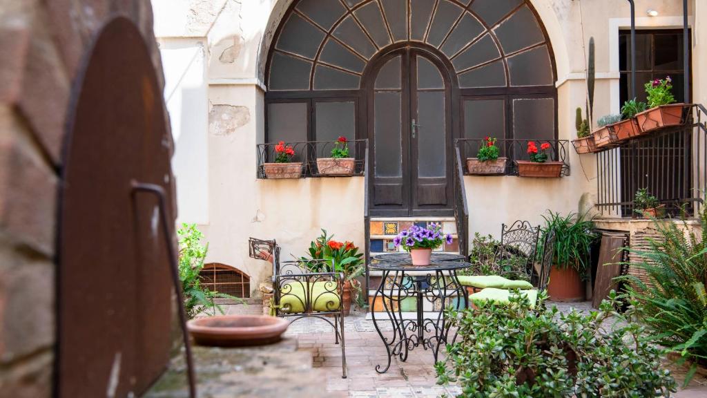 patio ze stołem i krzesłami przed budynkiem w obiekcie Casa Rodriguez - Iglesias w mieście Iglesias
