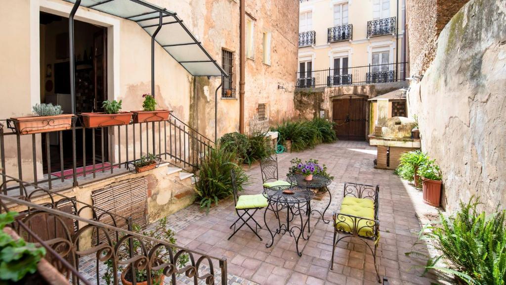 patio ze stołem i krzesłami na dziedzińcu w obiekcie Casa Rodriguez - Iglesias w mieście Iglesias