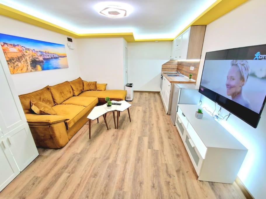 a living room with a couch and a flat screen tv at Yellow studio in Varna City
