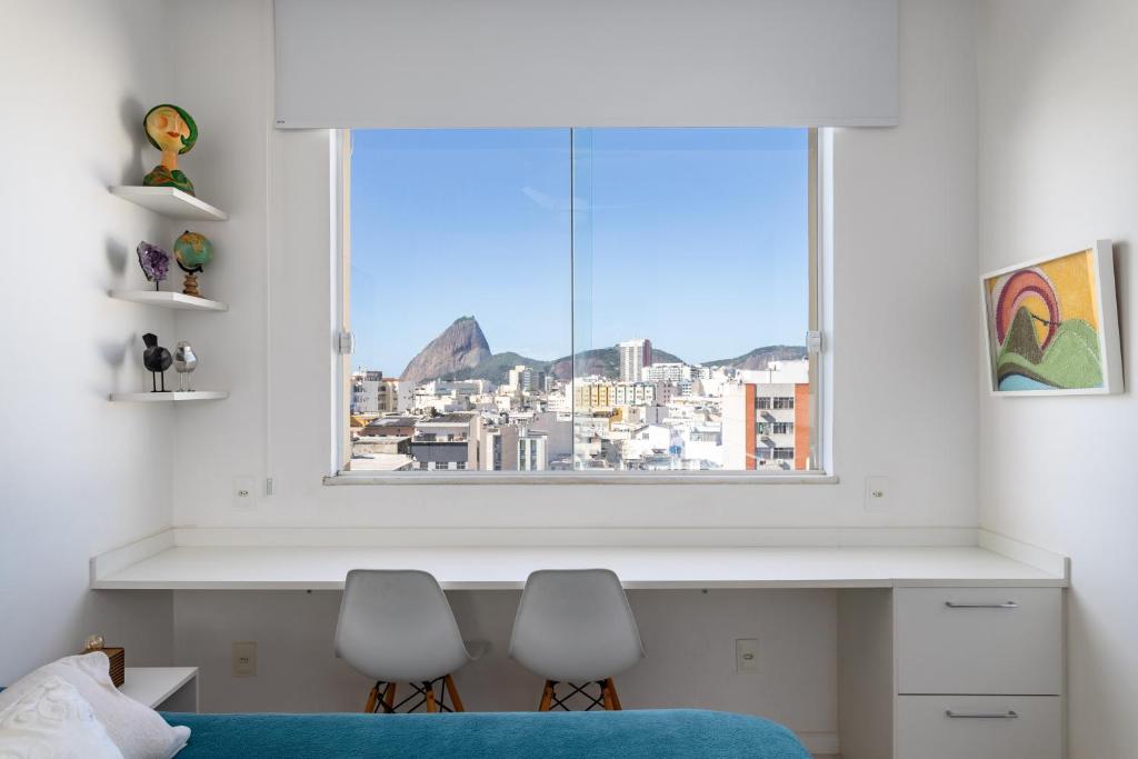 1 dormitorio con 2 sillas y ventana en Loft Catete, en Río de Janeiro