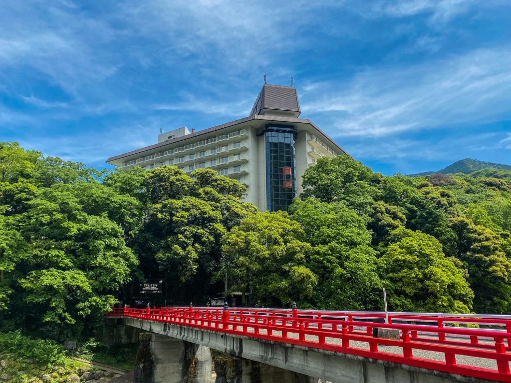 a building with a red bridge over a river at Yumoto Fujiya Hotel in Hakone