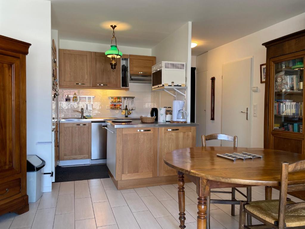 a kitchen with a wooden table and a dining room at Charming flat just outside Paris w free Private Parking in Saint-Ouen