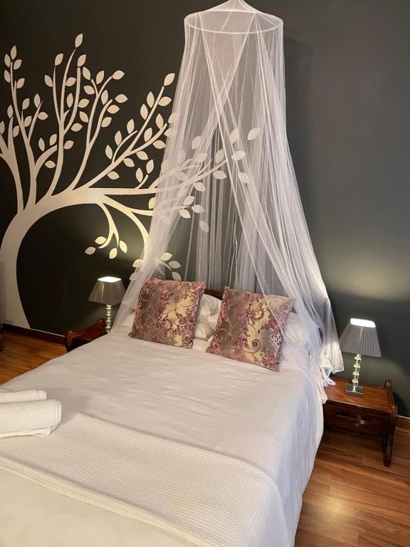 a bedroom with a white bed with a canopy at Moments Guest House in Klerksdorp