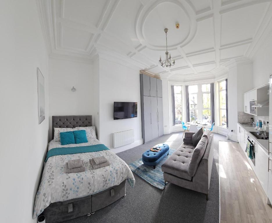 1 dormitorio blanco grande con 1 cama y 1 sofá en Edgerton Studios, en Huddersfield