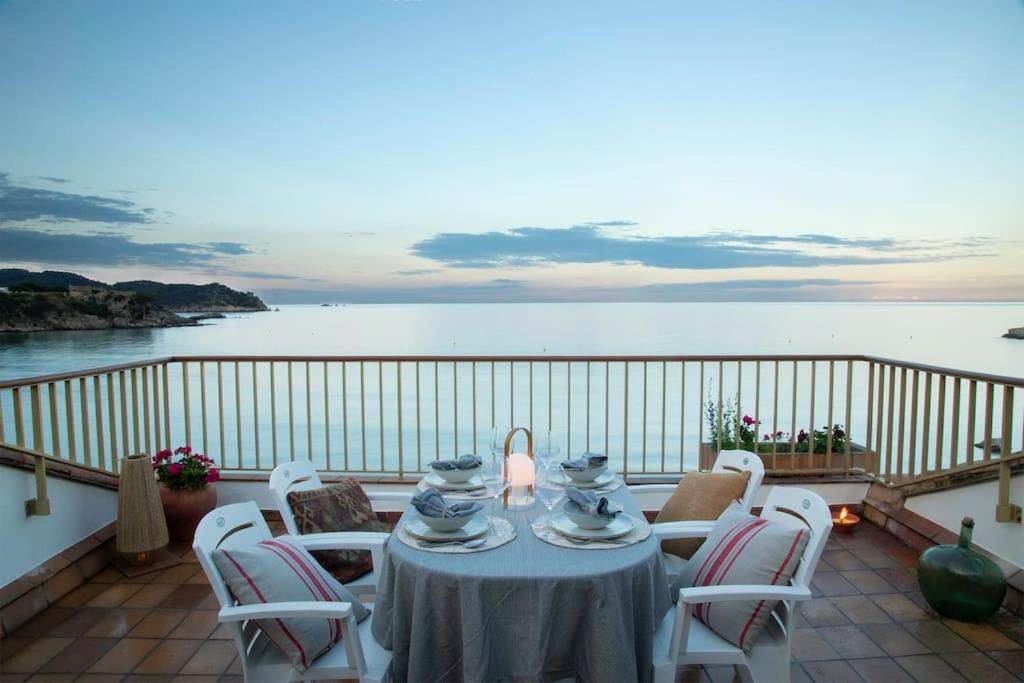 d'une table et de chaises sur un balcon donnant sur l'eau. dans l'établissement La Caseta de la Fosca, en el mar. By the sea., à Palamós