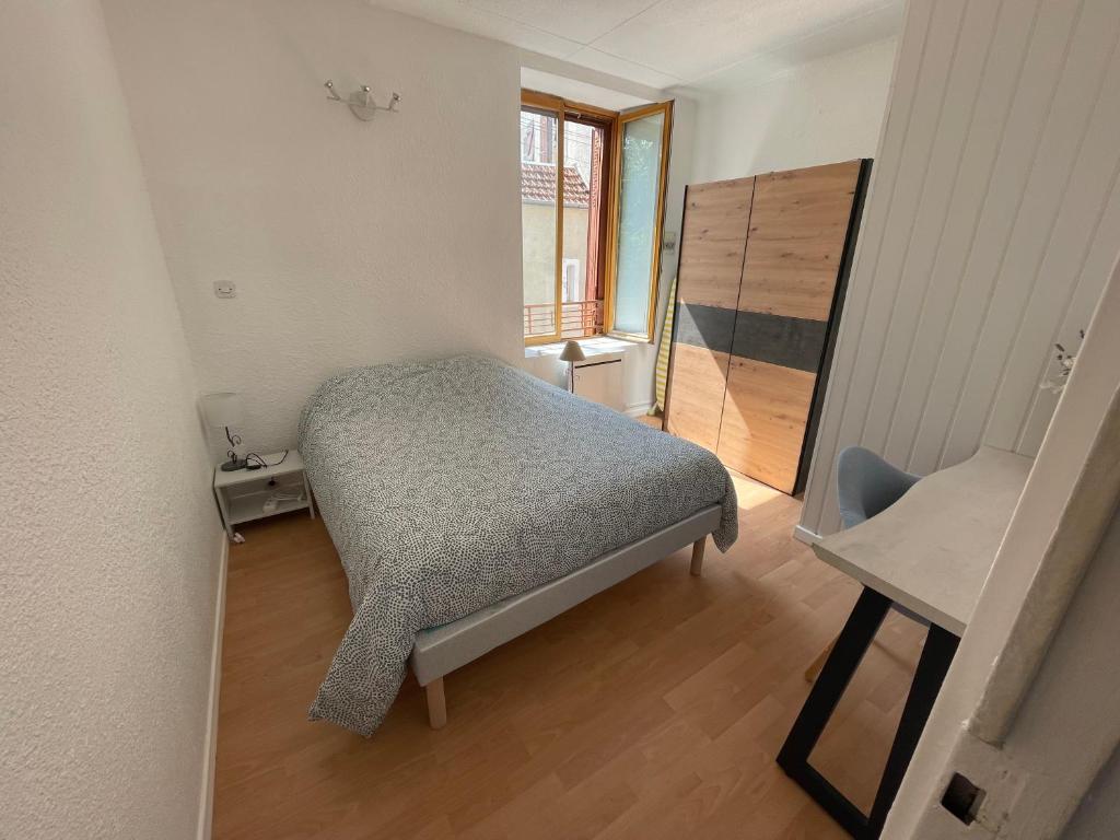 een kleine slaapkamer met een bed en een dressoir bij Nid douillet proche des Thermes in Bourbonne-les-Bains