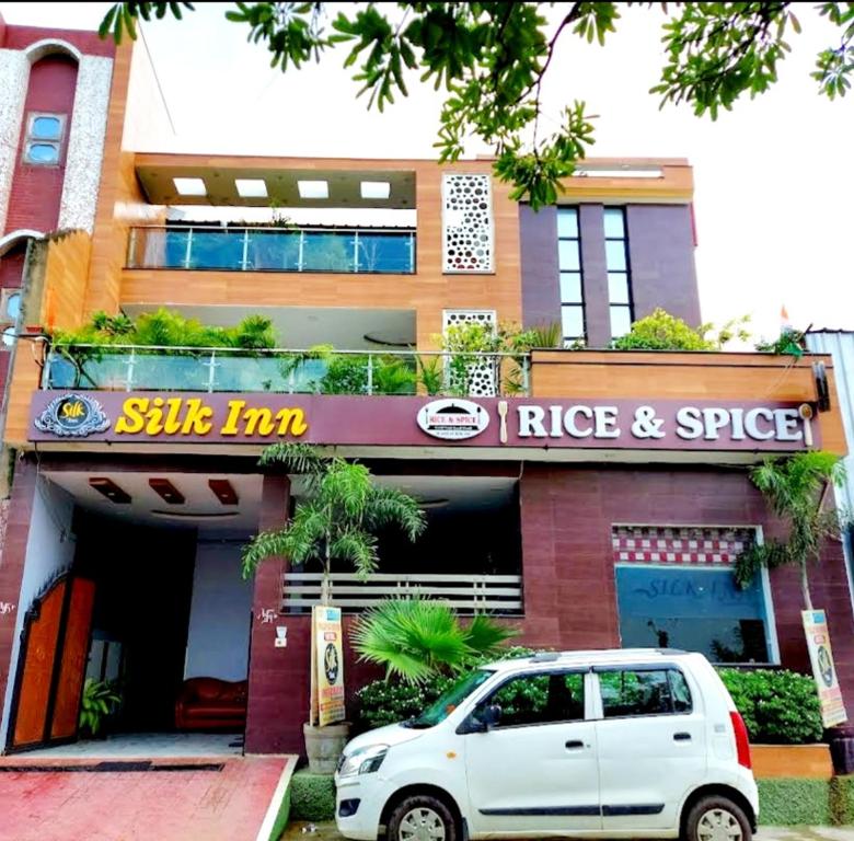 um carro branco estacionado em frente a um edifício em Hotel Silk Inn Luxury At No Cost em Lucknow